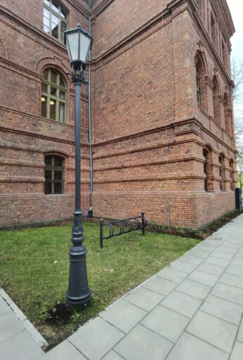 Farol histórico no centro de Żyrardów, tendo como pano de fundo a arquitetura industrial em tijolo vermelho